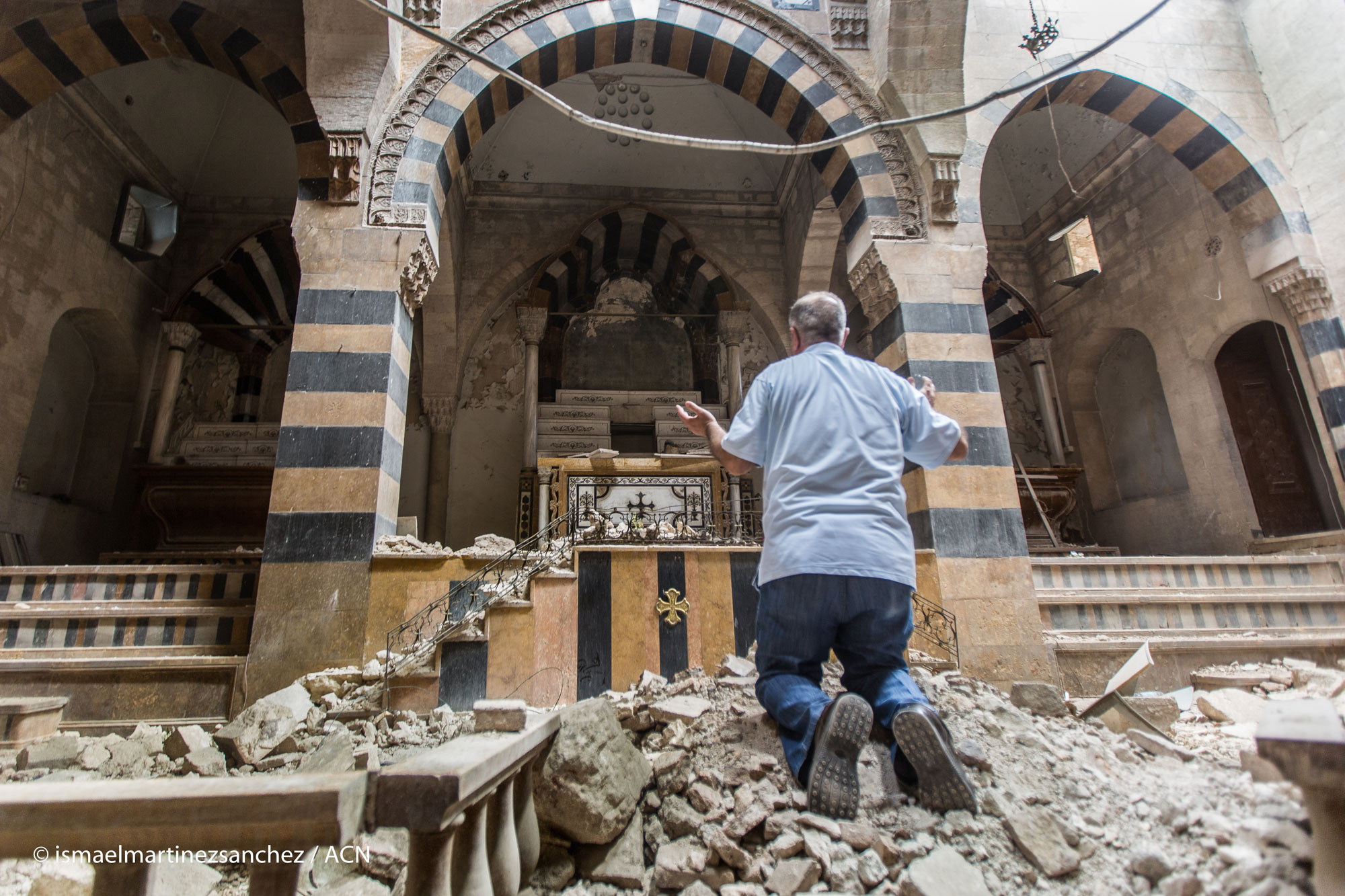Ein Mann betet in einer zerstörten Kirche in Syrien