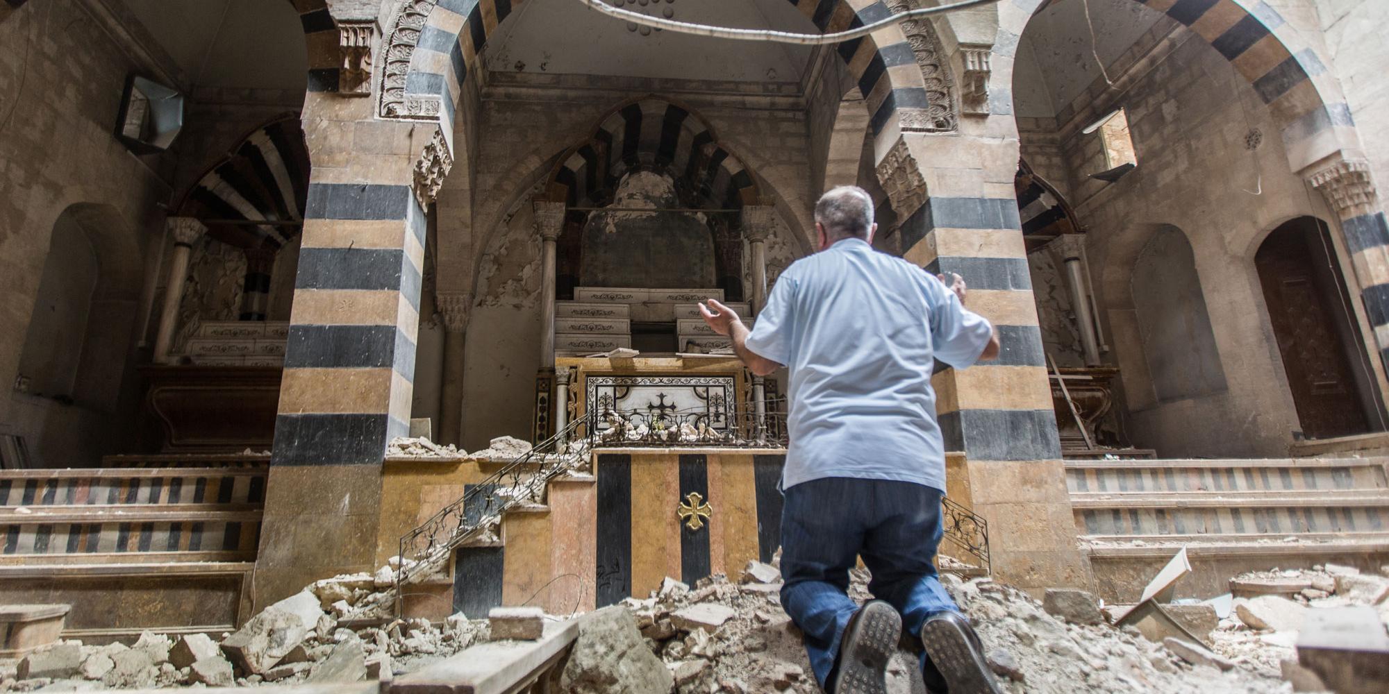 Ein Mann betet in einer zerstörten Kirche in Syrien (c) Kirche in Not Ein Mann betet in einer zerstörten Kirche in Syrien