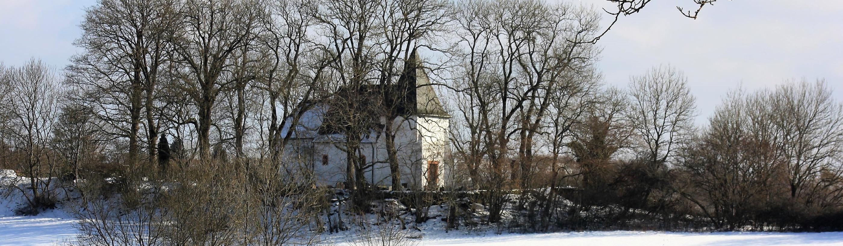 Zu sehen ist die Kirche am Weinfelder Maar im Winter.