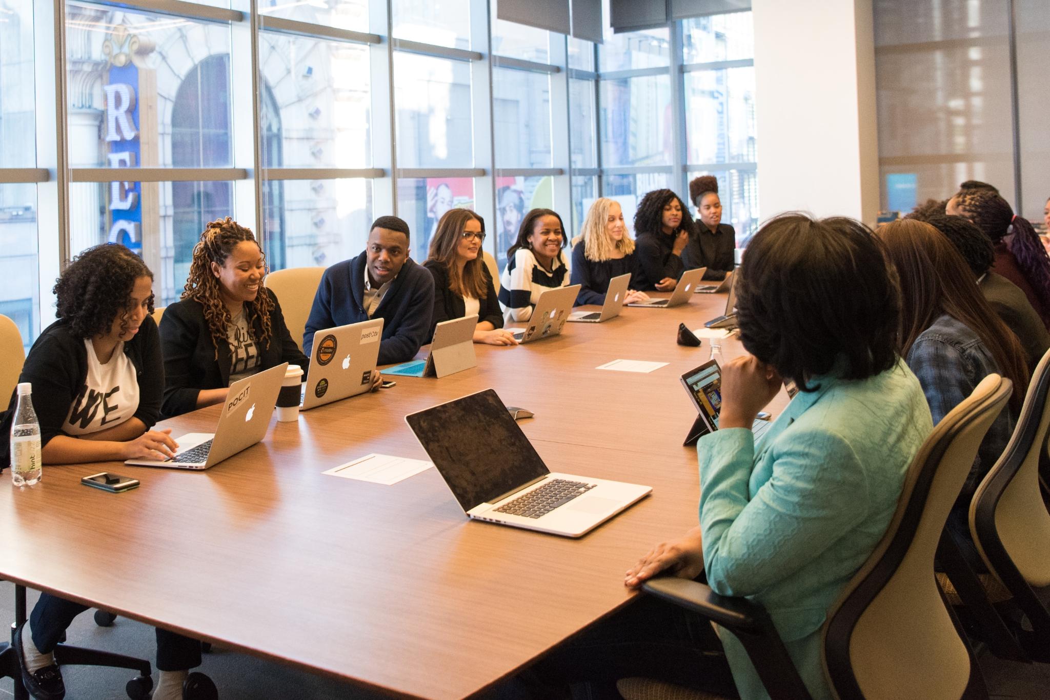 Viele Leute sitzen mit Laptop in Meeting